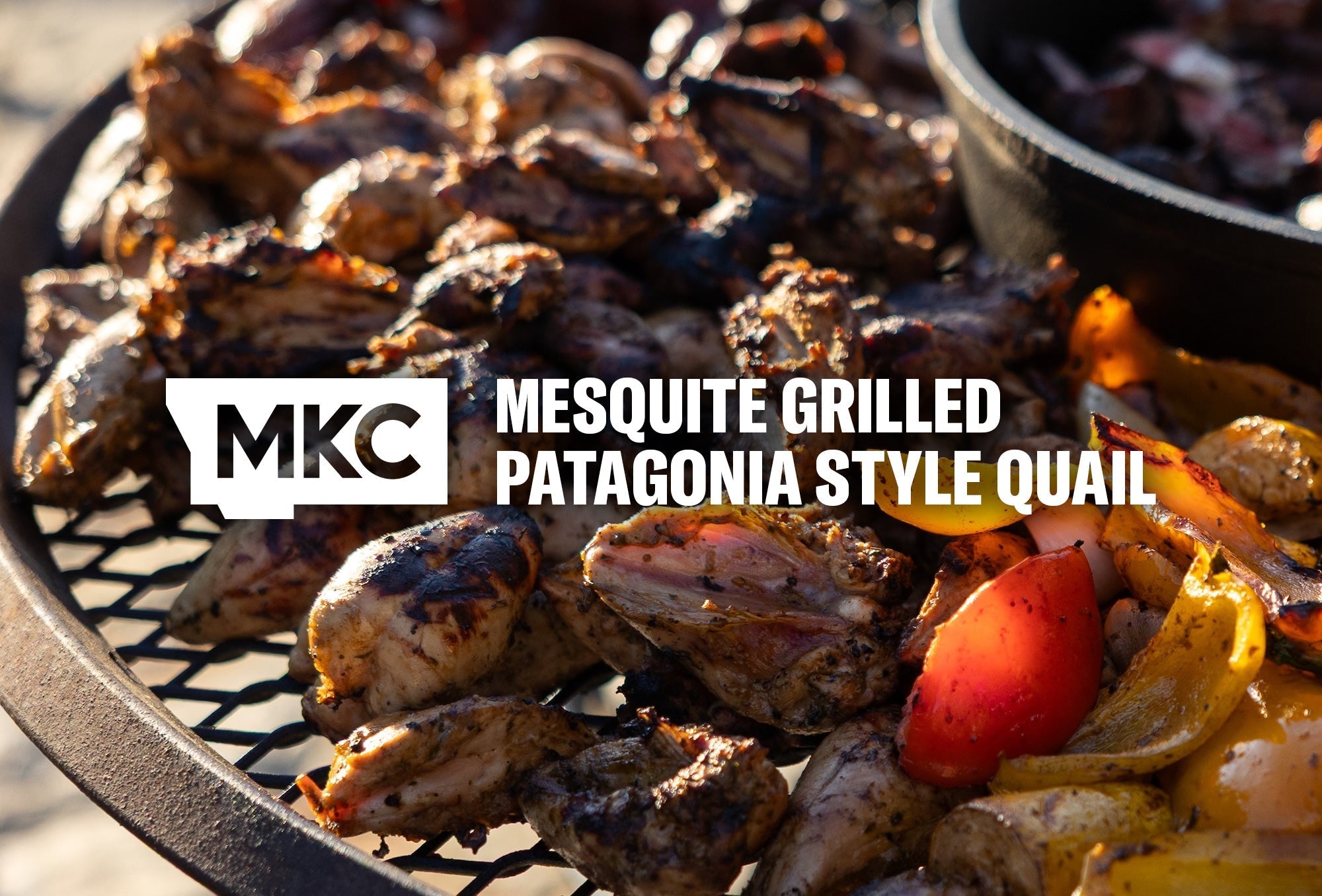 Grilled quail and vegetables cooking over open mesquite coals, showing charred skin and smoky color.