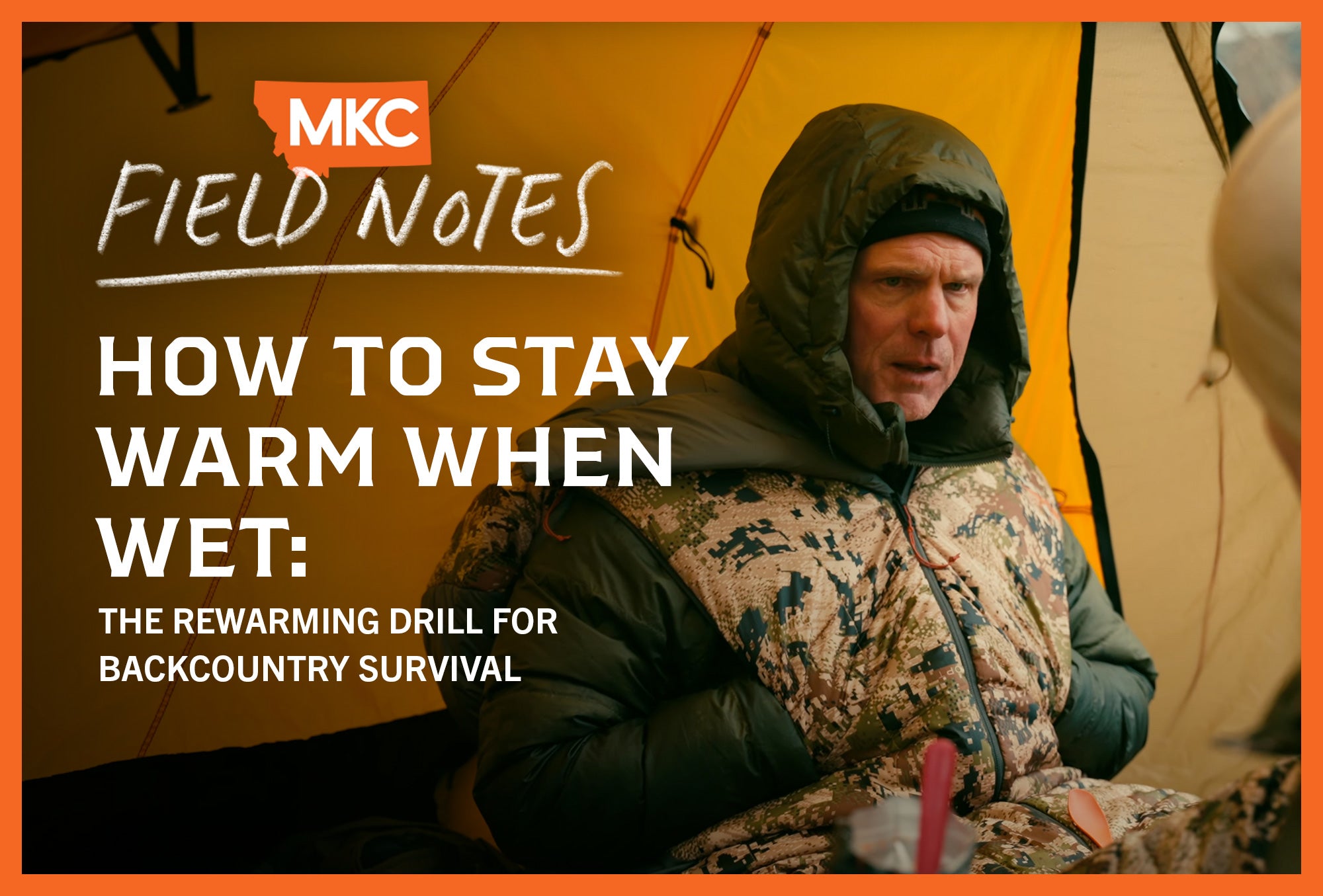 John Barklow in winter hunting gear with a hooded jacket sits inside an orange tent.