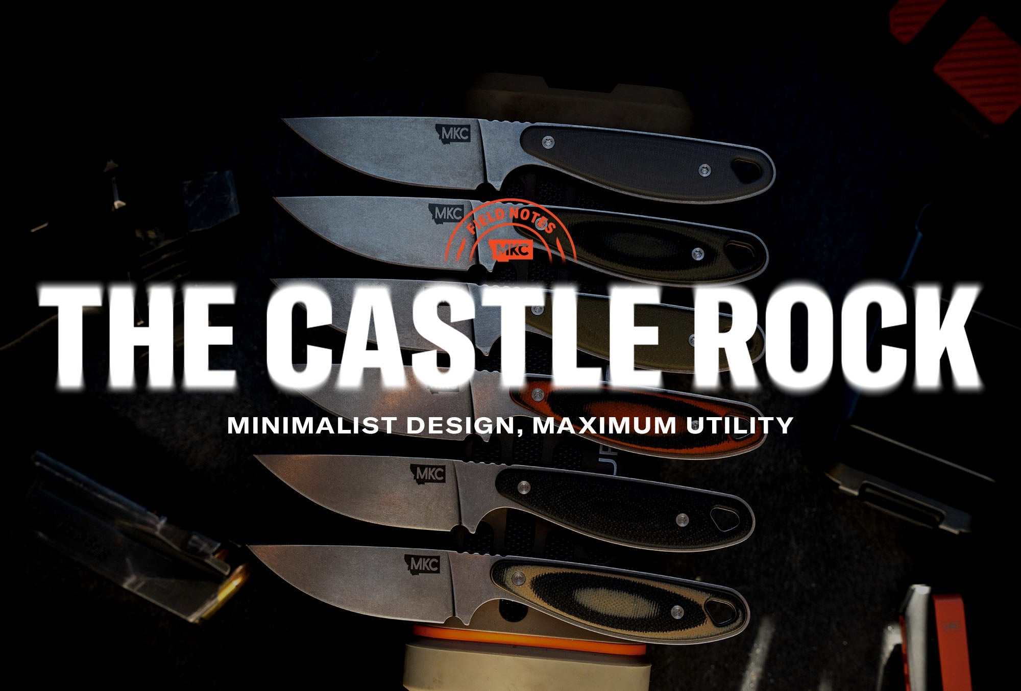 Six MKC knives displayed on a dark surface, including the Castle Rock fixed blade with its clean, minimalist profile.