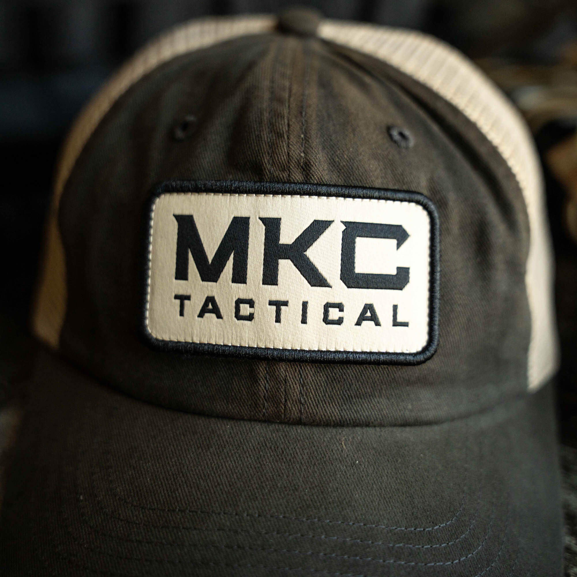 MKC Tactical Classic Trucker hat featuring a prominent logo on a dark fabric with mesh back for breathability.