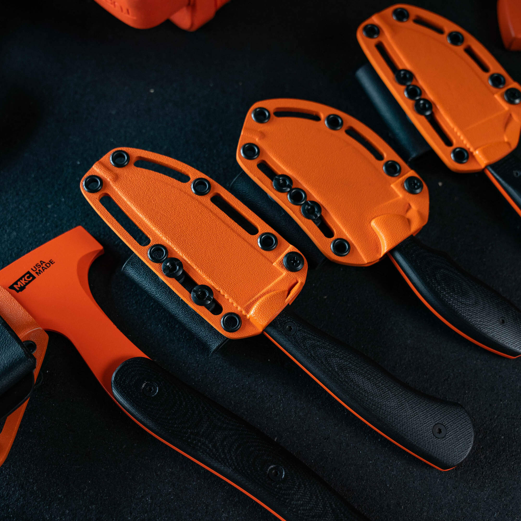 Full set of 8 Blaze Orange Cerakote knives with durable sheaths, designed for outdoor use and visibility.