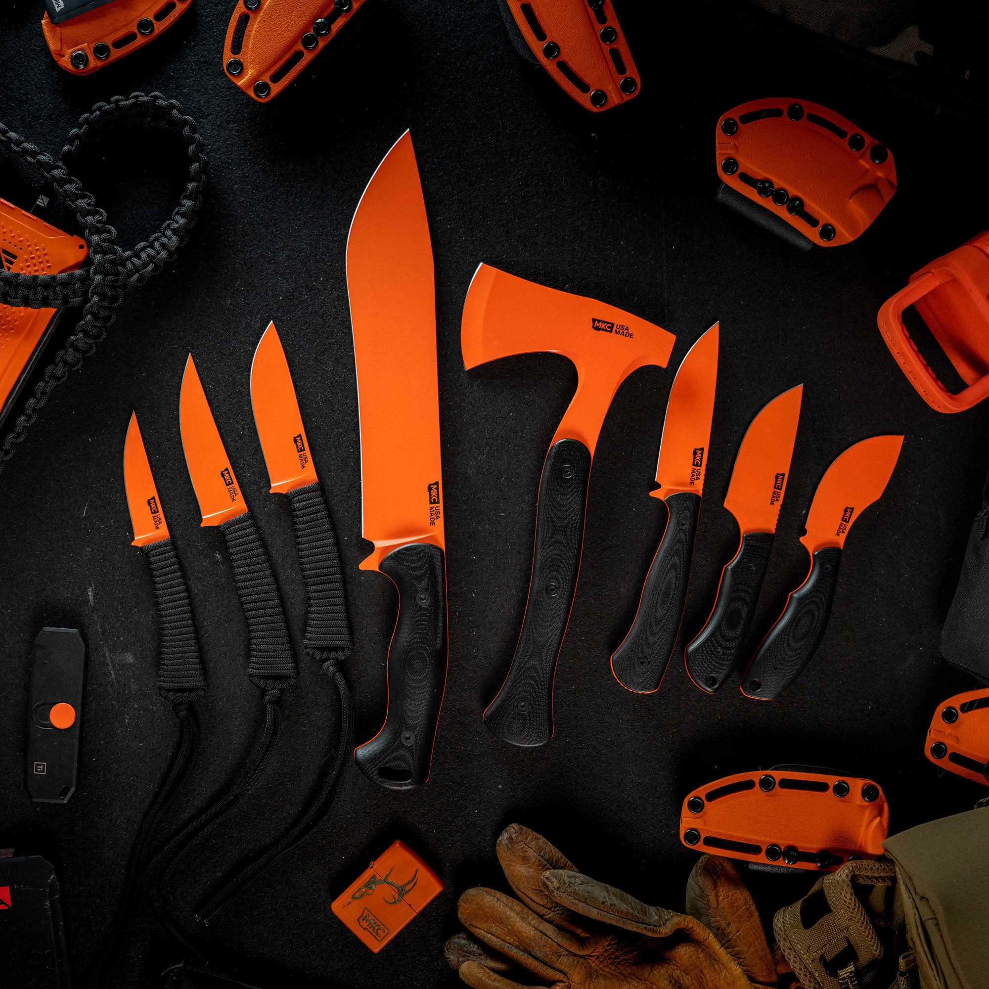 Full set of eight Blaze Orange Cerakote knives, including various sizes and a hatchet, arranged on a dark surface.