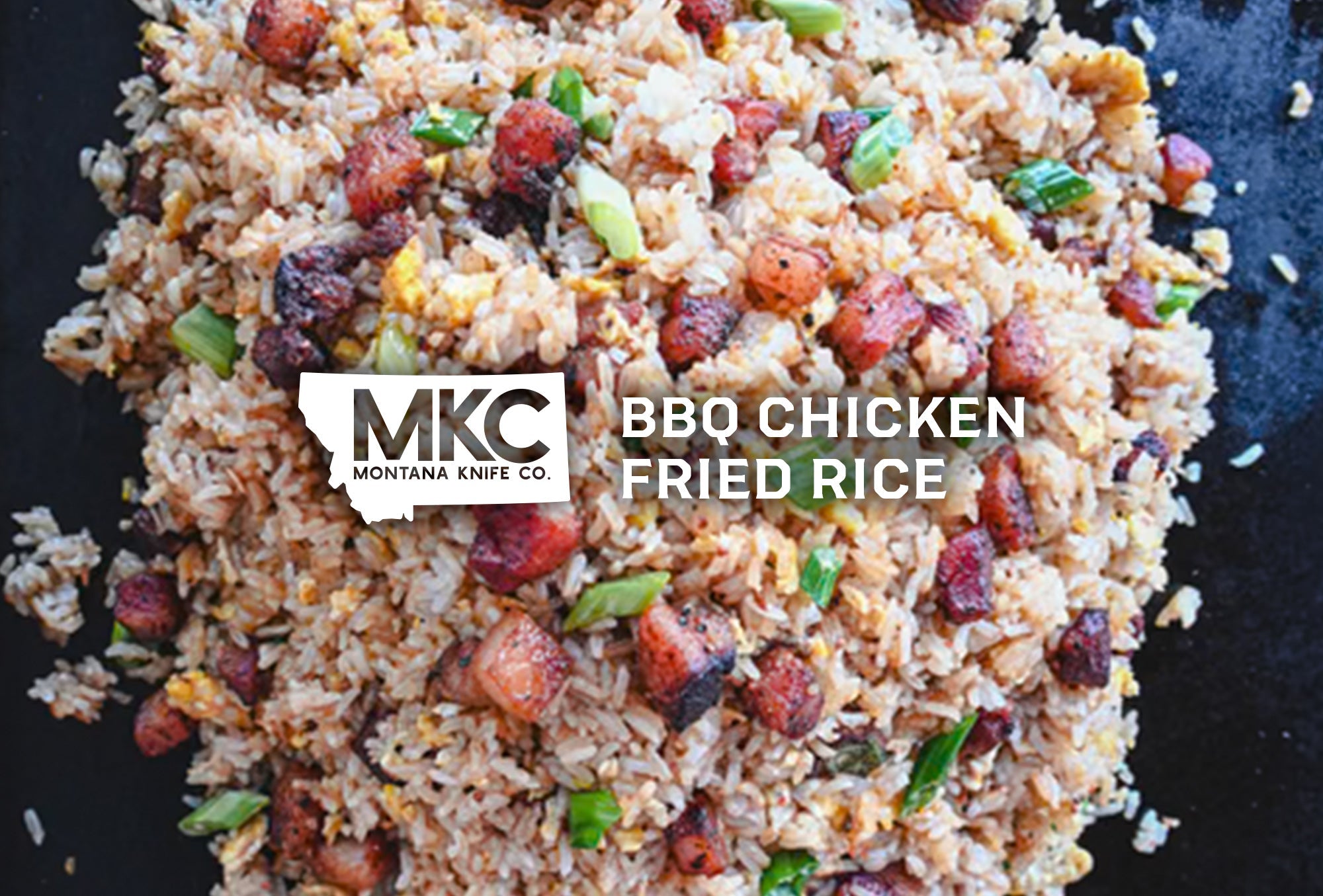 Close-up view of BBQ chicken fried rice with eggs, scallions, soy sauce, sesame oil, butter, and seasoning.