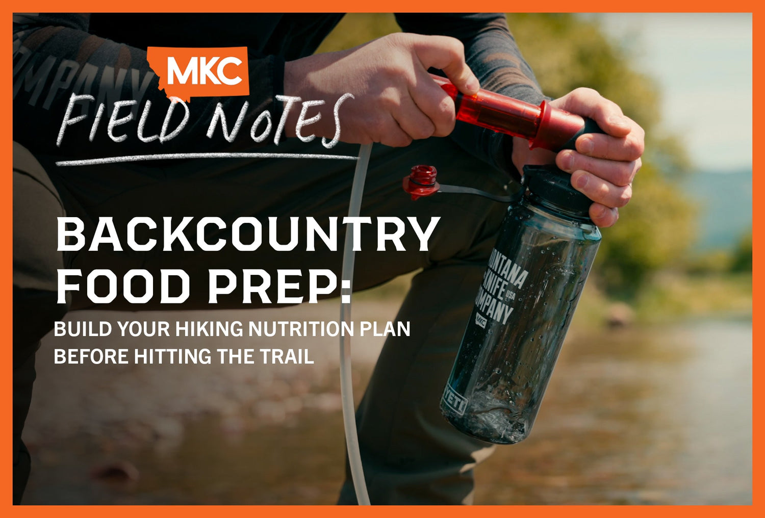 Man holding water bottle beside stream, highlighting hydration in backcountry food prep and nutrition planning.