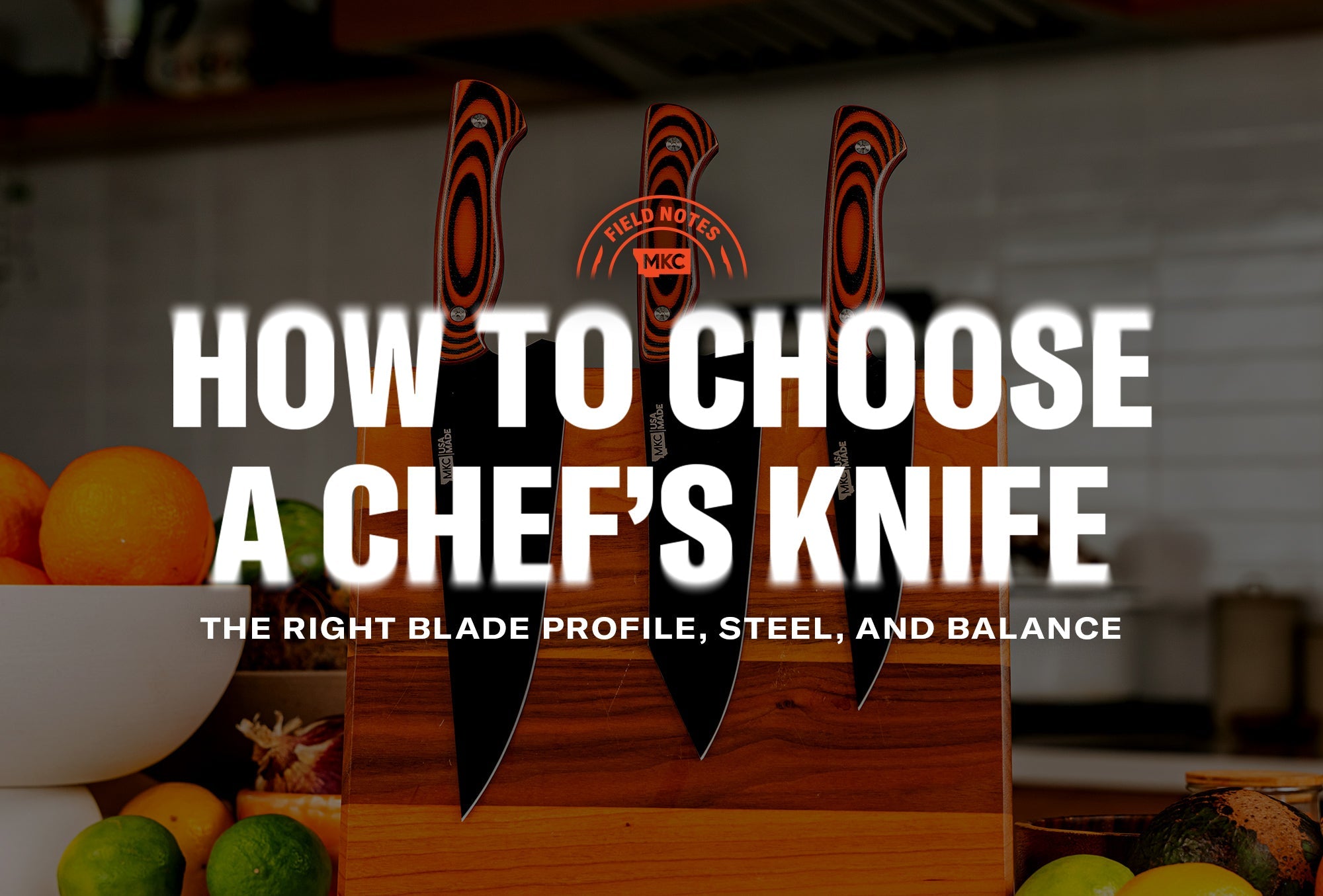 Set of three MKC chef’s knives on a wooden board next to oranges and limes.