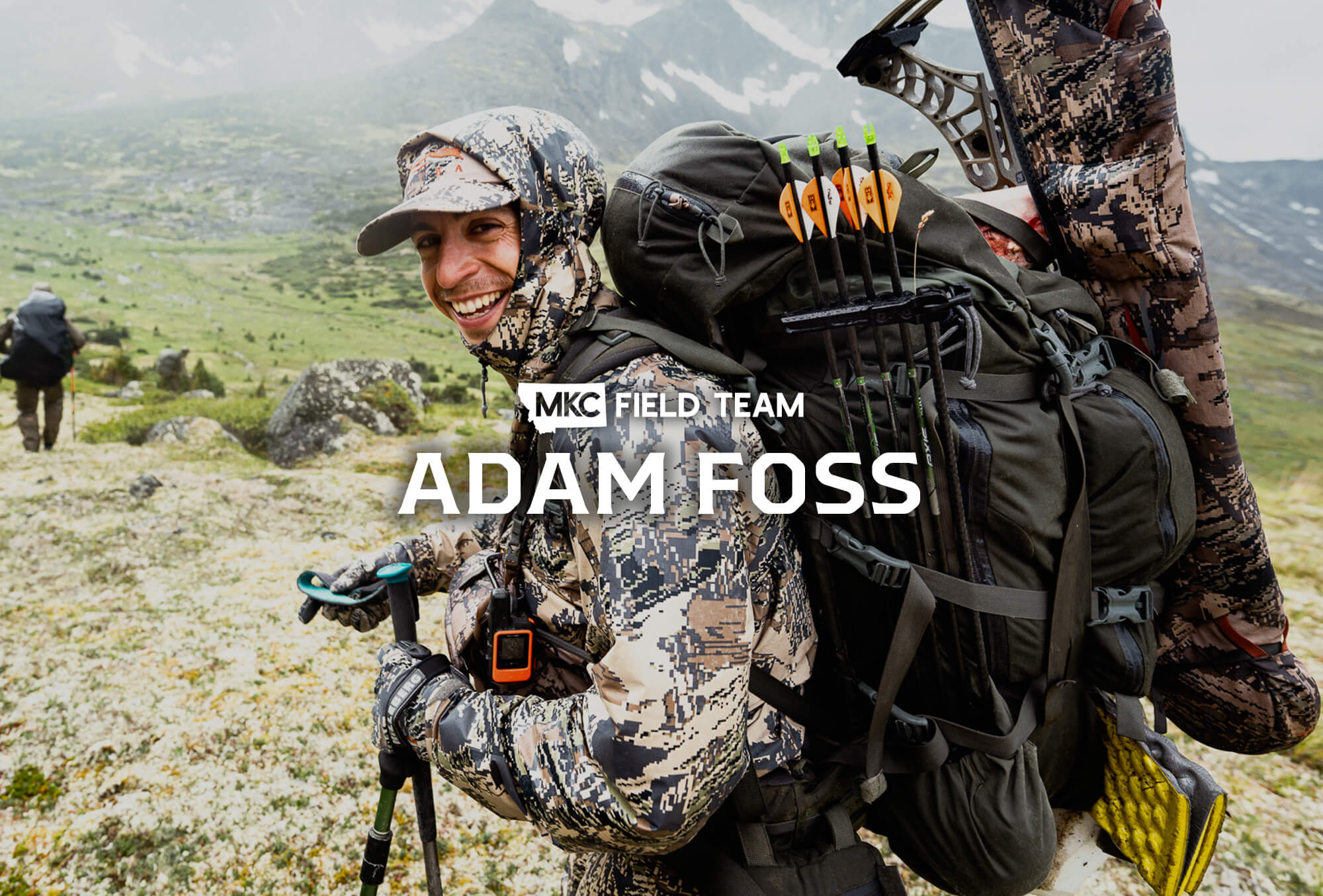 Adam Foss leans forward, laughing, to grip the photographer’s hand on a trail in the mountains.