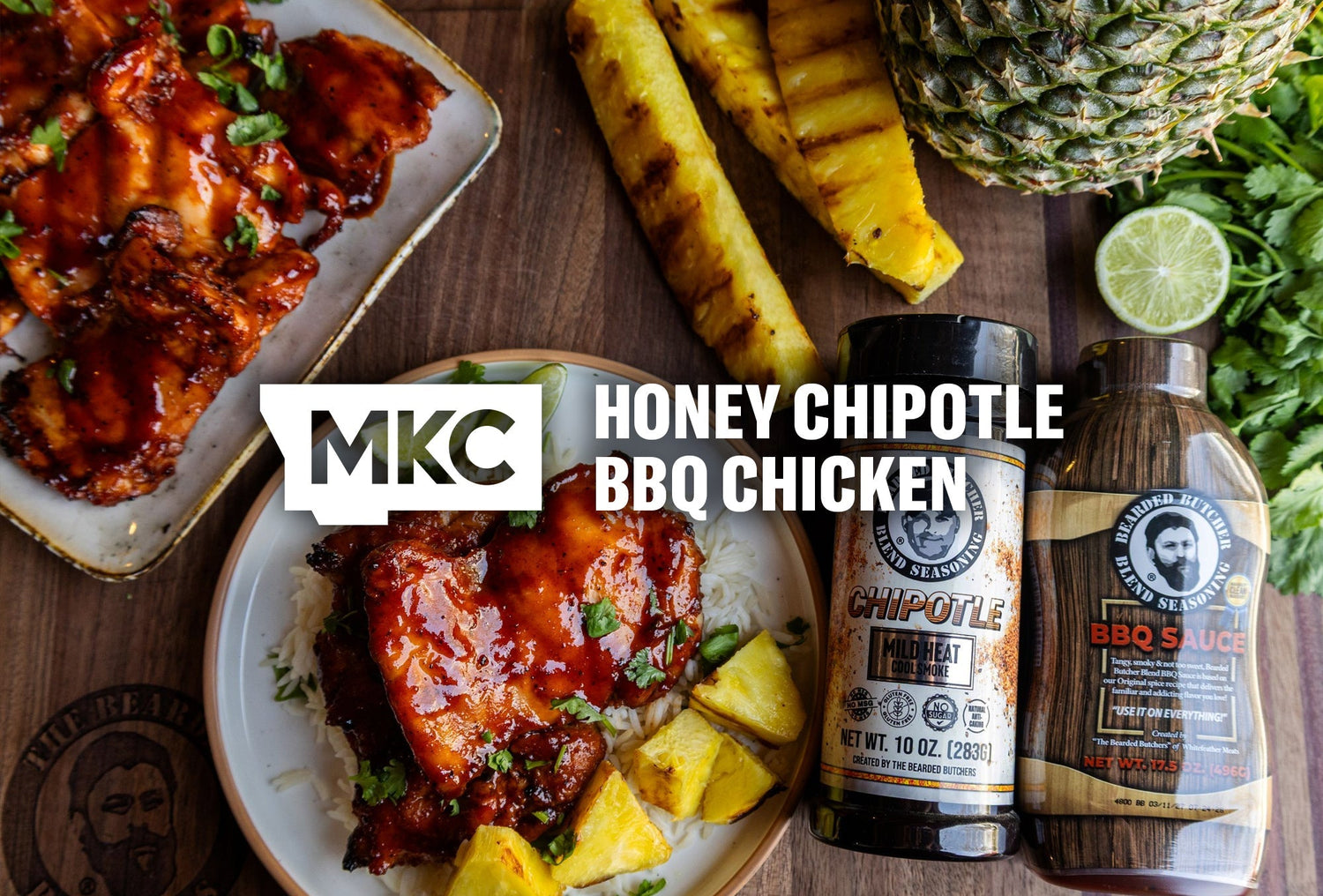 Honey chipotle BBQ chicken thighs with grilled pineapple, rice, and seasoning bottles on a rustic table.