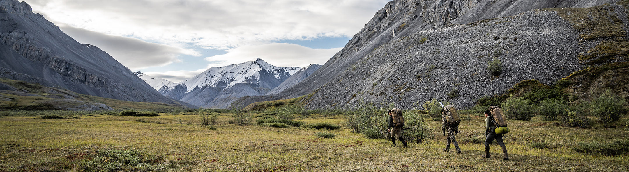 Hunters walking through mountain range