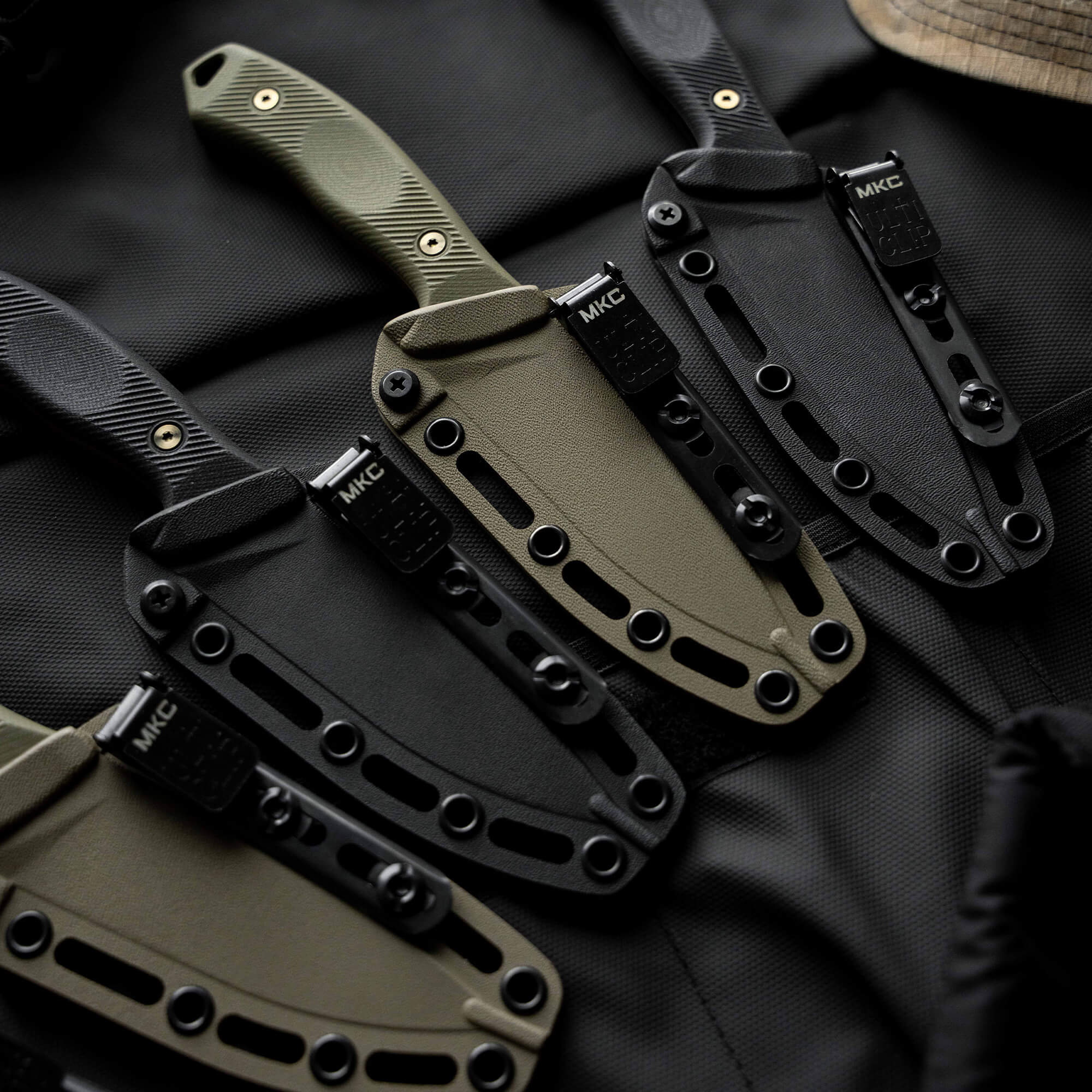 Montana Knife Company TF24 knives in various colors with sheaths, showcasing durable design for outdoor use.